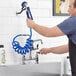A man using a hose to open a Waterloo pet grooming faucet.