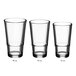 A row of empty Acopa Select stackable cooler/mixing glasses on a white background.