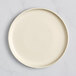 An Acopa Pangea white matte coupe porcelain plate on a white surface.