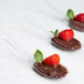 Three WNA Comet clear plastic Asian soup spoons filled with chocolate pudding and strawberries.