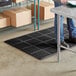 A man standing on a black Choice anti-fatigue floor mat.