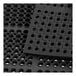 A black rubber anti-fatigue floor mat with holes in it.
