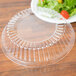 A Dart clear plastic lid on a clear plastic bowl of salad.
