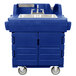 A navy blue plastic Cambro CamKiosk portable sink with a stainless steel sink on a counter with wheels.