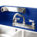 A navy blue Cambro CamKiosk with a stainless steel sink and faucet.