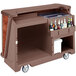 A brown Cambro Sedona Designer Series portable bar cart with bottles on it.