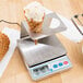 A Cardinal Detecto digital scale with waffle cones in a cone holder.