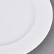 A white Arcoroc porcelain brunch plate with a white rim on a gray surface.