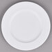 A white porcelain brunch plate with a white rim on a gray surface.