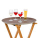A Thunder Group brown oval non-skid serving tray with white wine glasses on it.