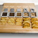 Choice Prep 1/4" Blade Assembly and Push Block on a cutting board with different types of french fries.