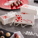 A group of white Valentine's Day candy boxes with red hearts and text.