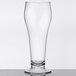 A customizable clear plastic footed pilsner glass on a table.