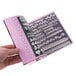 A hand holding a pink Ateco Cake Decorating Tip Reference Manual book with a variety of shapes on the cover.