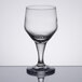 A close-up of a Libbey clear wine glass on a reflective surface.