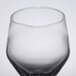 A close up of a clear Libbey Estate wine glass with a small amount of water in it.