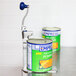 An Edlund commercial can opener clamped to a metal stand with a can of pumpkin soup on a counter.