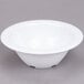 A white Thunder Group Nustone melamine bowl on a gray surface.
