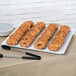 A white square melamine display platter with a tray of bagels.