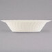 A white Fineline Flairware plastic bowl with wavy lines on it.