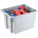 A gray Rubbermaid Palletote box filled with red plastic containers.