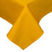 A yellow tablecloth with a folded edge on a table.