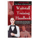 The Waiter, Waitress & Waitstaff Training Handbook on a counter in a farm-to-table restaurant with a woman in a black vest.