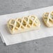 Two Bridor spinach and feta pastries with lattice tops on a white napkin.
