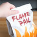 A hand holding a Bagcraft Packaging foil BBQ bag with a Flame Pak design.
