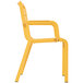 A yellow plastic Grosfillex outdoor armchair with armrests.