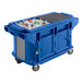 A blue Cambro Versa Ultra work table with a large cooler full of bottles.