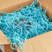 A box with Spring-Fill Pastel Blue Radiance Crinkle Cut Paper Shred inside.