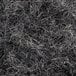 A close-up of a pile of thin black paper shreds.