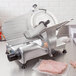 A Globe G10 meat slicer on a counter with meat.