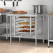 A school kitchen with a Regency stainless steel table with food on it.