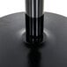 A Lancaster Table & Seating black cast iron bar height table base with a black metal pole.
