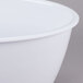 A white oval melamine casserole dish with a lid.