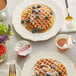 A plate of waffles with blueberries and Runamok Sugarmaker's Cut Pure Maple Syrup on a table in a breakfast diner.