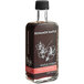 A brown Runamok bottle of Hibiscus Flower-Infused Maple Syrup with white text and flowers on the label and a black cap.