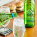 A green bottle of Mountain Valley Sparkling Water being poured into a glass.