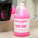 A pink bottle of Advantage Chemicals hand soap on a counter.