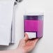 A hand using a pink Advantage Chemicals liquid soap dispenser.