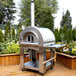 A stainless steel Pinnacolo outdoor pizza oven on a deck.