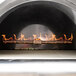 A Pinnacolo black hybrid wood/gas-fired pizza oven with flames inside.