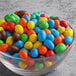 A bowl of M&M's Peanut Milk Chocolate candies on a table.