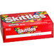 A red SKITTLES candy box with colorful candies.