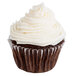 A chocolate cupcake with white frosting in a Hoffmaster white fluted baking cup.