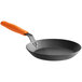 A black Lodge carbon steel fry pan with an orange silicone helper handle.