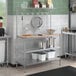 A kitchen with a Regency stainless steel baker's rack shelf holding utensils.