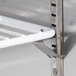 A close-up of a metal shelf on a white rack.
